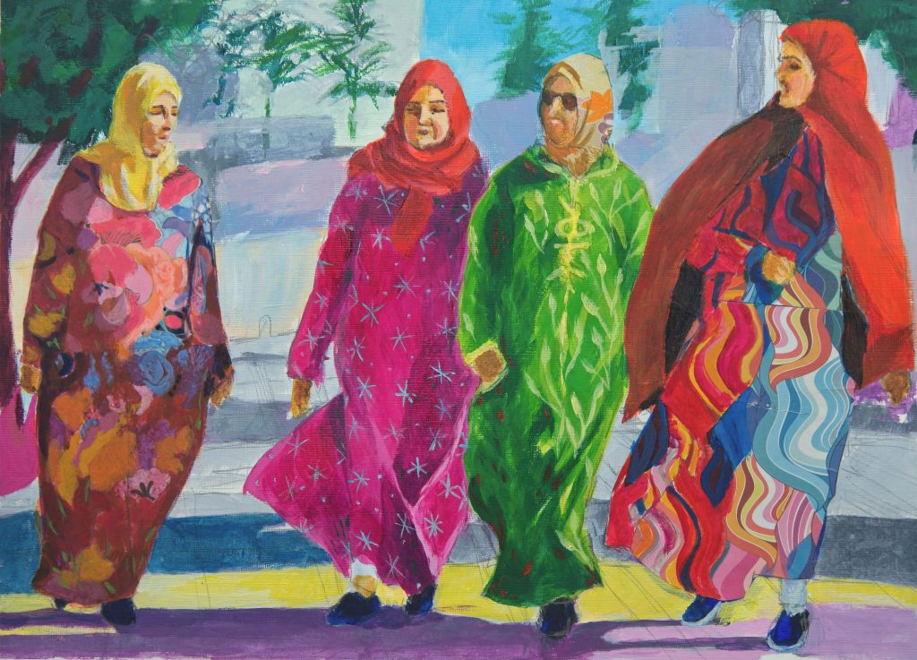 Four brighly dressed women walking against the wind