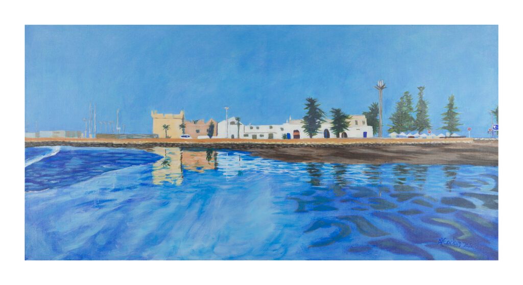 A very blue image of sea, a shoreline with buildings, and sky